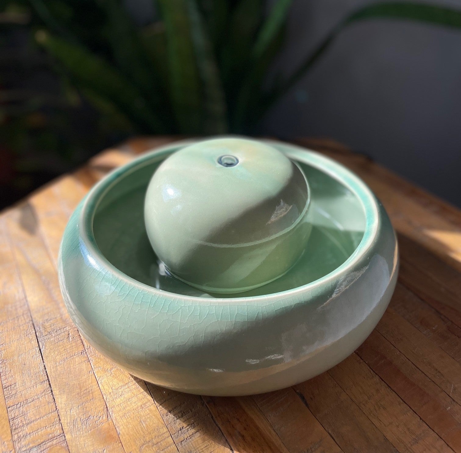 Feng Shui Brunnen Creme Keramik mit leiser Pumpe im Wohnzimmer
Handgefertigter Feng Shui Zimmerbrunnen auf Holztisch
Reichtumsbrunnen Feng Shui in Creme für Ruhe und Wohlstand im Feng Shui 